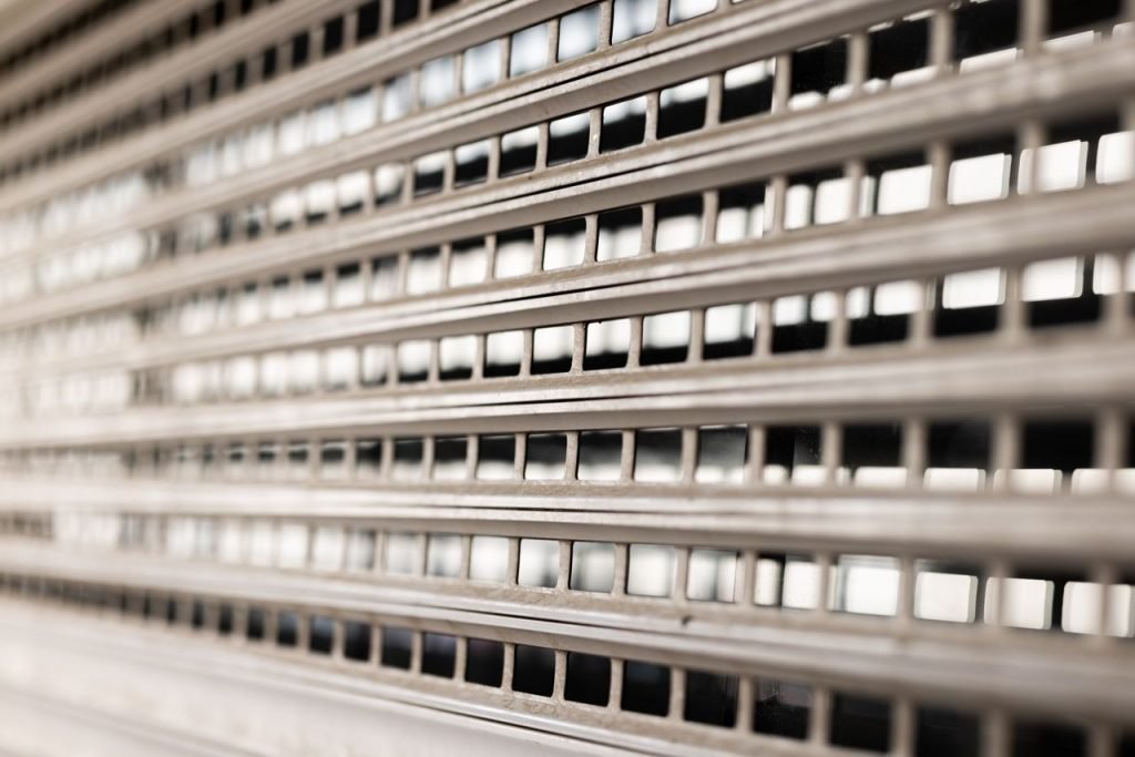 Close-up view of a metallic grated wall showcasing geometric patterns and textures.