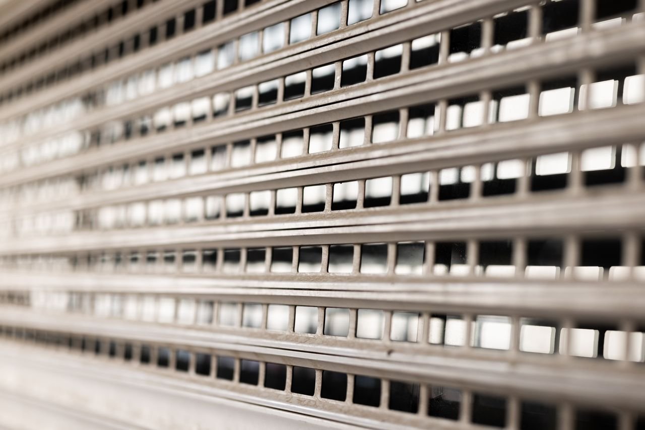 Close-up view of a metallic grated wall showcasing geometric patterns and textures.